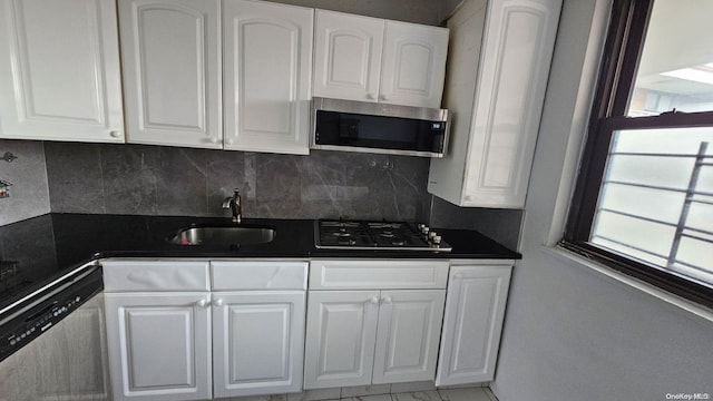 kitchen featuring backsplash, sink, white cabinetry, and stainless steel appliances