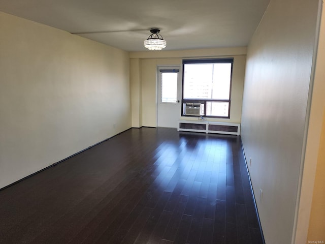 empty room with cooling unit and dark wood-style floors