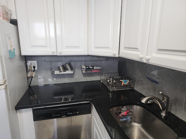 kitchen featuring dishwasher, a sink, backsplash, and freestanding refrigerator
