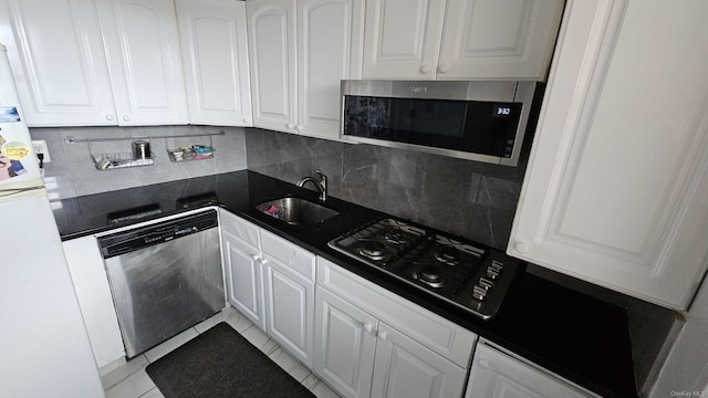kitchen with appliances with stainless steel finishes, a sink, and white cabinets