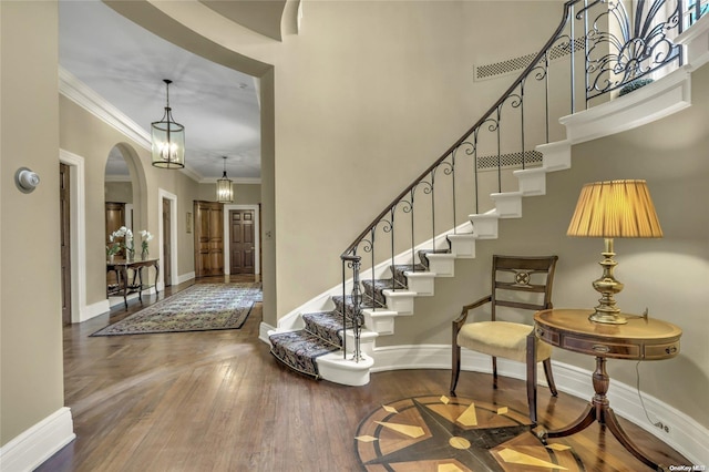 entrance foyer with wood-type flooring and crown molding