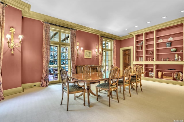 dining area featuring crown molding, french doors, and light carpet