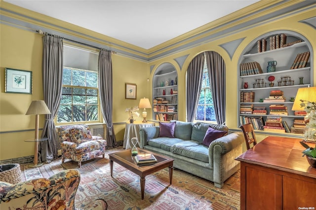 living area featuring crown molding and built in features