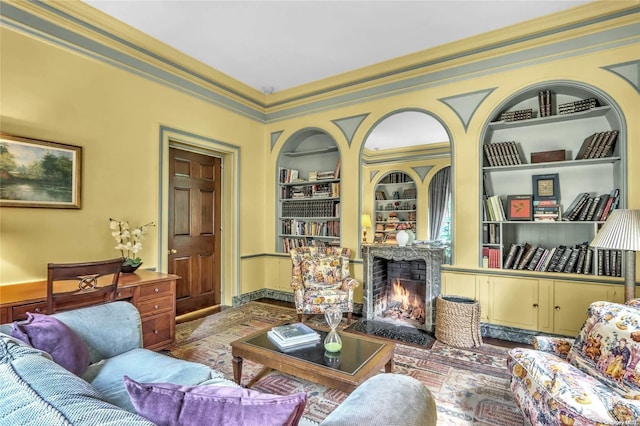 living room featuring built in shelves and ornamental molding