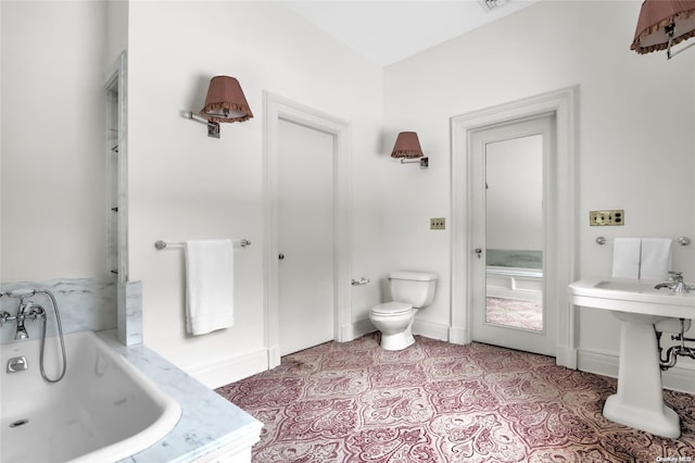 bathroom with tile patterned flooring, toilet, sink, and a tub