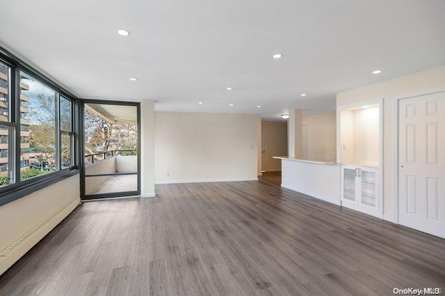 unfurnished room featuring dark hardwood / wood-style flooring and baseboard heating