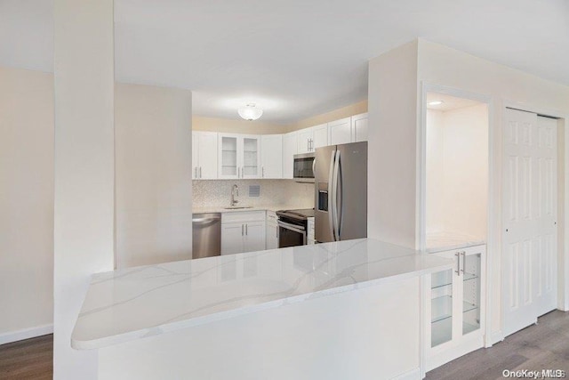 kitchen featuring white cabinetry, light stone countertops, kitchen peninsula, and stainless steel appliances