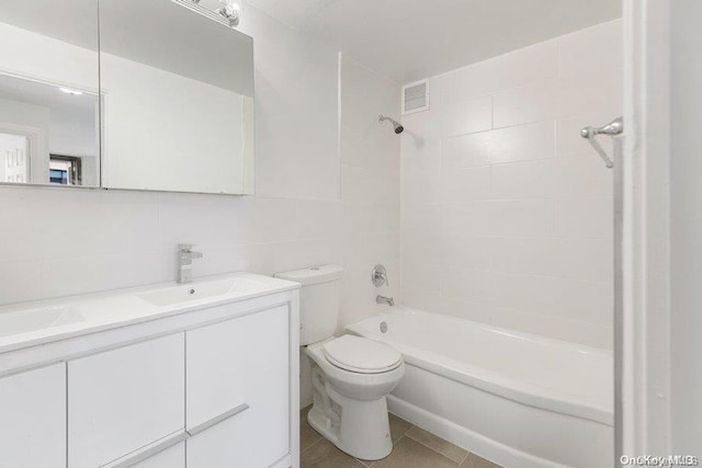 full bathroom featuring tasteful backsplash, vanity, tile walls, toilet, and tiled shower / bath