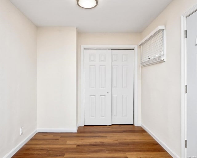 unfurnished bedroom with wood-type flooring and a closet