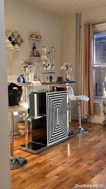 bar featuring hardwood / wood-style flooring and a textured ceiling