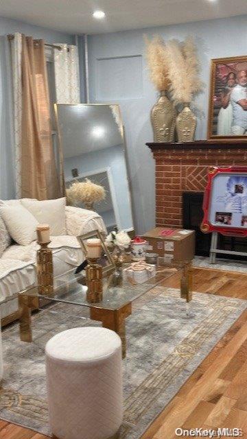 living area featuring wood-type flooring and a fireplace