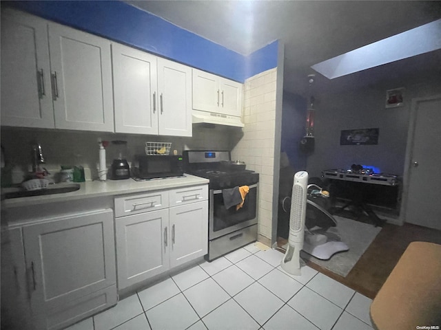 kitchen featuring black appliances, white cabinets, light tile patterned floors, tasteful backsplash, and extractor fan