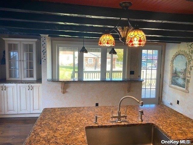 kitchen with beam ceiling, dark hardwood / wood-style flooring, sink, and white cabinets