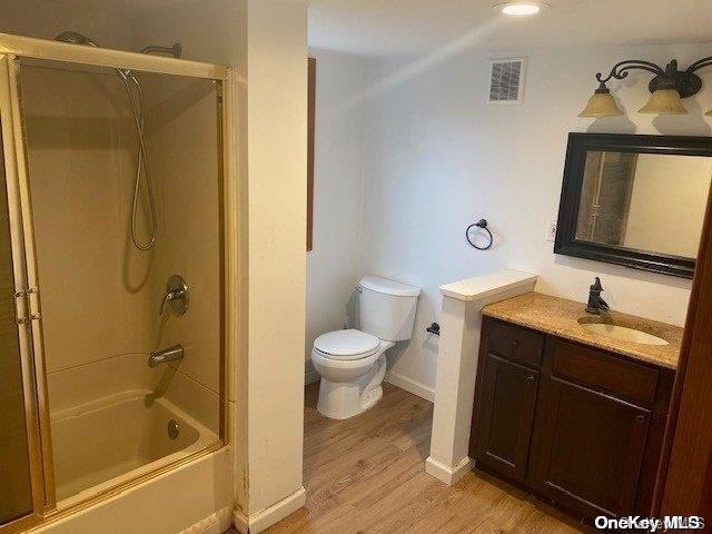 full bathroom featuring bathtub / shower combination, vanity, hardwood / wood-style flooring, and toilet