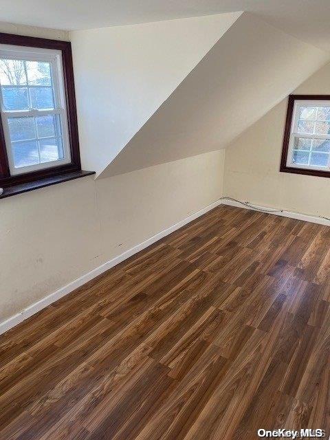 bonus room featuring dark hardwood / wood-style floors and lofted ceiling