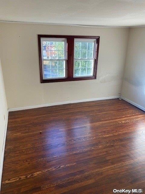 empty room with dark hardwood / wood-style flooring