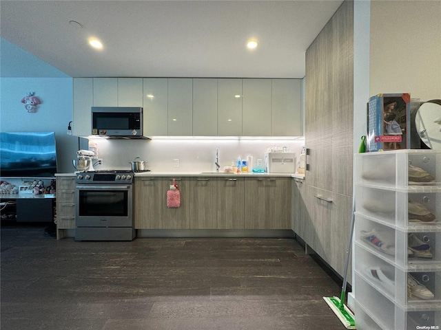 kitchen with sink, dark hardwood / wood-style flooring, light brown cabinets, and appliances with stainless steel finishes