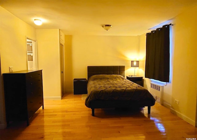 bedroom with radiator and light hardwood / wood-style flooring