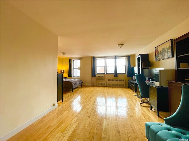 office with radiator heating unit and light hardwood / wood-style floors