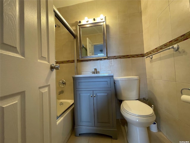 full bathroom with tile patterned floors, vanity, tile walls, toilet, and tiled shower / bath