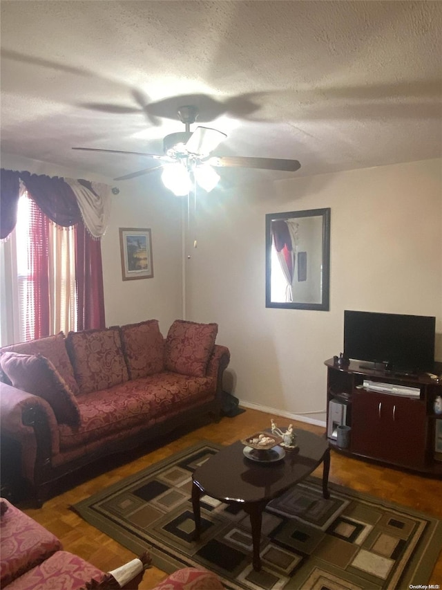living room with a textured ceiling and ceiling fan
