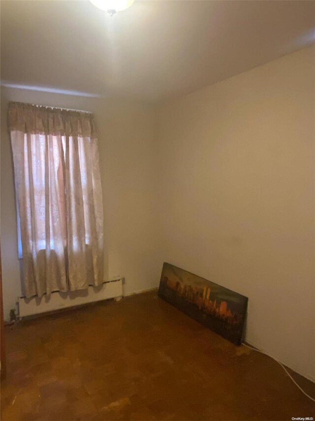 unfurnished room with a baseboard radiator