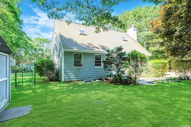 rear view of property with a lawn