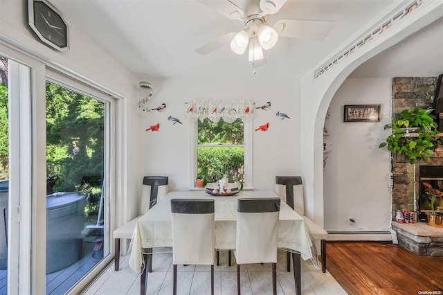 dining space with light hardwood / wood-style floors, a baseboard radiator, and ceiling fan