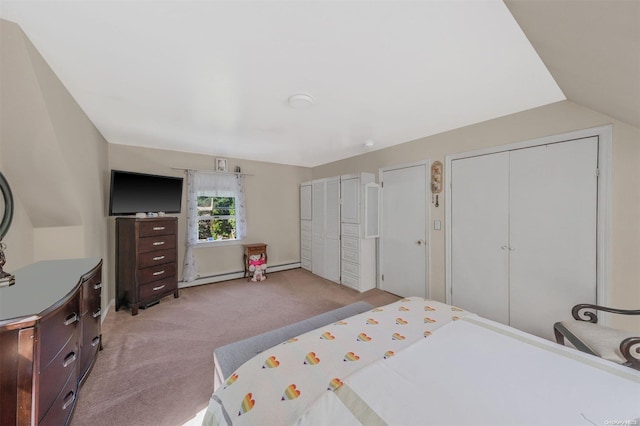 bedroom featuring light carpet, vaulted ceiling, baseboard heating, and multiple closets