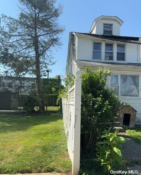 view of side of home with a yard