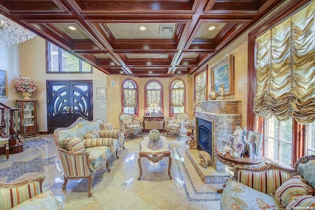 living room with a stone fireplace, beamed ceiling, coffered ceiling, and ornamental molding