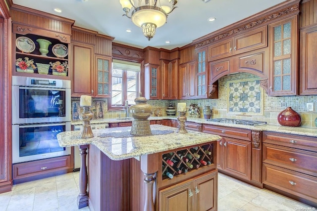 kitchen with light stone countertops, appliances with stainless steel finishes, decorative backsplash, and a kitchen island