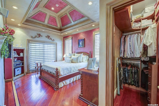 bedroom with crown molding, a closet, coffered ceiling, and hardwood / wood-style flooring