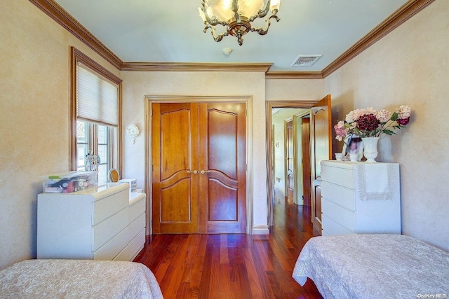 bedroom with crown molding, dark wood-type flooring, and an inviting chandelier