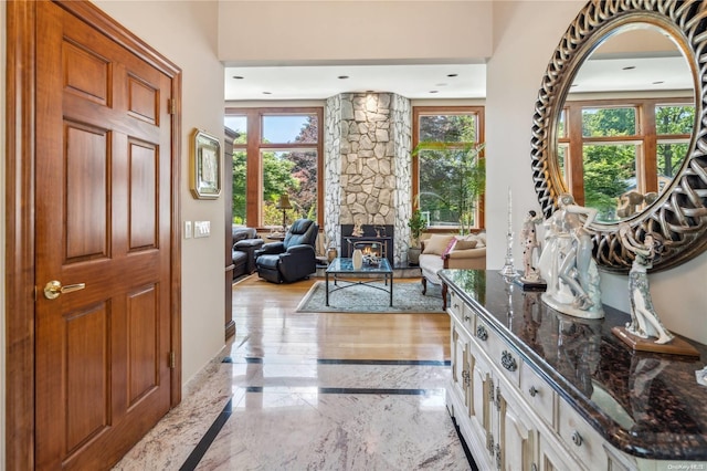 entryway featuring a healthy amount of sunlight and a wood stove