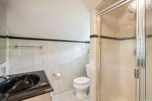 bathroom featuring tile patterned floors, walk in shower, vanity, tile walls, and toilet