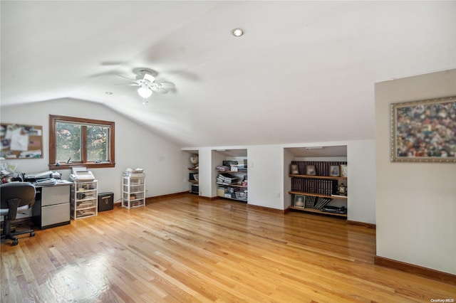 office area with ceiling fan, vaulted ceiling, built in features, and light hardwood / wood-style flooring