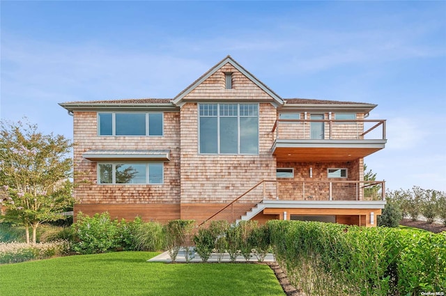 back of property featuring a yard and a balcony