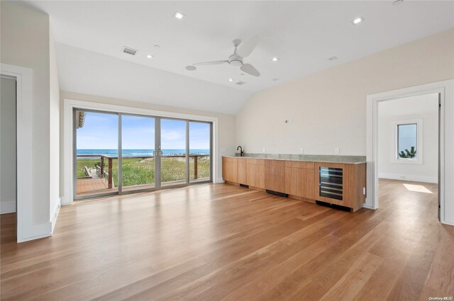 451 Dune Rd, Westhampton Beach, NY 11978 - unfurnished living room featuring wine cooler, lofted ceiling, light wood-style floors, ceiling fan, and wet bar
