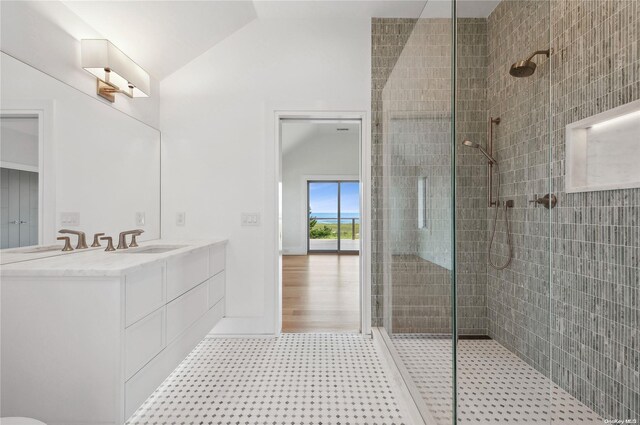 451 Dune Rd, Westhampton Beach, NY 11978 - bathroom featuring lofted ceiling, a tile shower, double vanity, and tile patterned floors