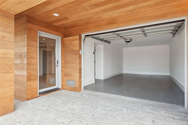 451 Dune Rd, Westhampton Beach, NY 11978 - interior space featuring baseboards, a garage door opener, and wood walls