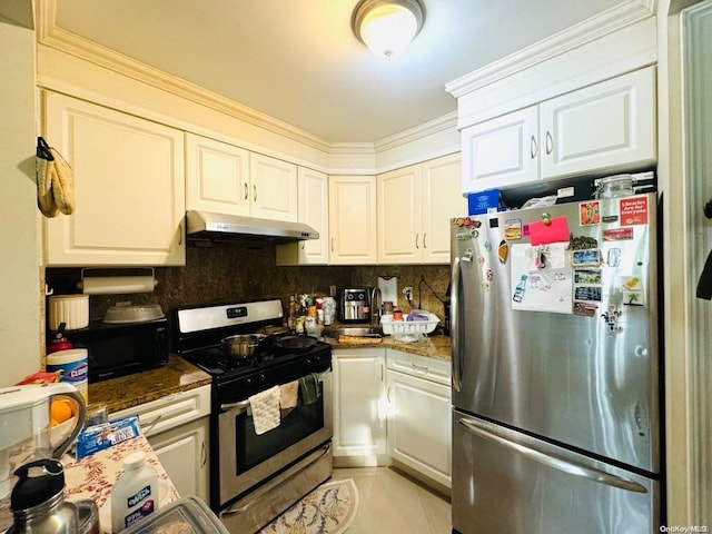 kitchen with stainless steel appliances, light tile patterned floors, backsplash, dark stone counters, and white cabinets