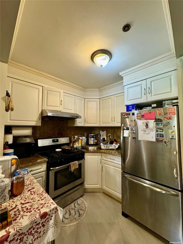 kitchen featuring appliances with stainless steel finishes, tasteful backsplash, crown molding, light tile patterned floors, and white cabinetry