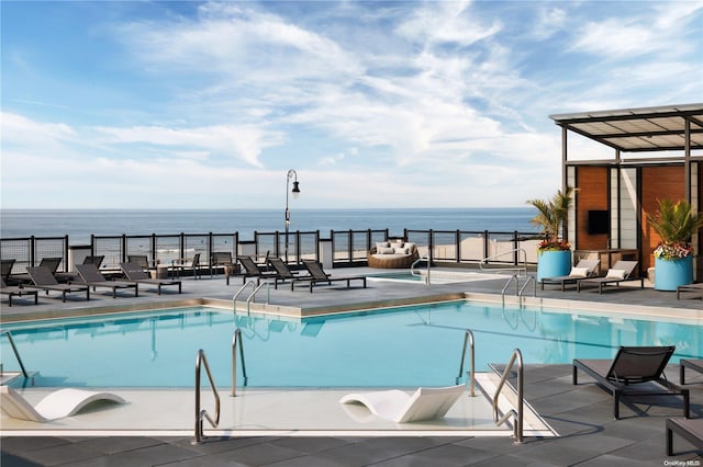 view of pool with a patio area and a water view