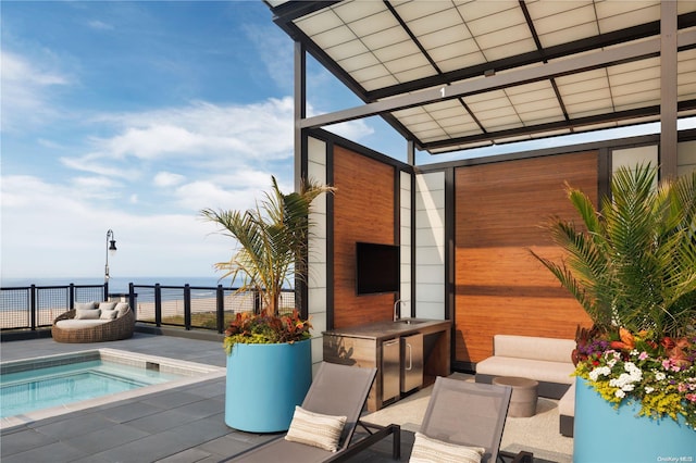 view of patio with a jacuzzi, an outdoor hangout area, a water view, and sink