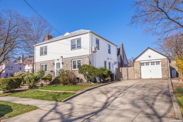 view of front of home featuring a front yard, a garage, and an outdoor structure