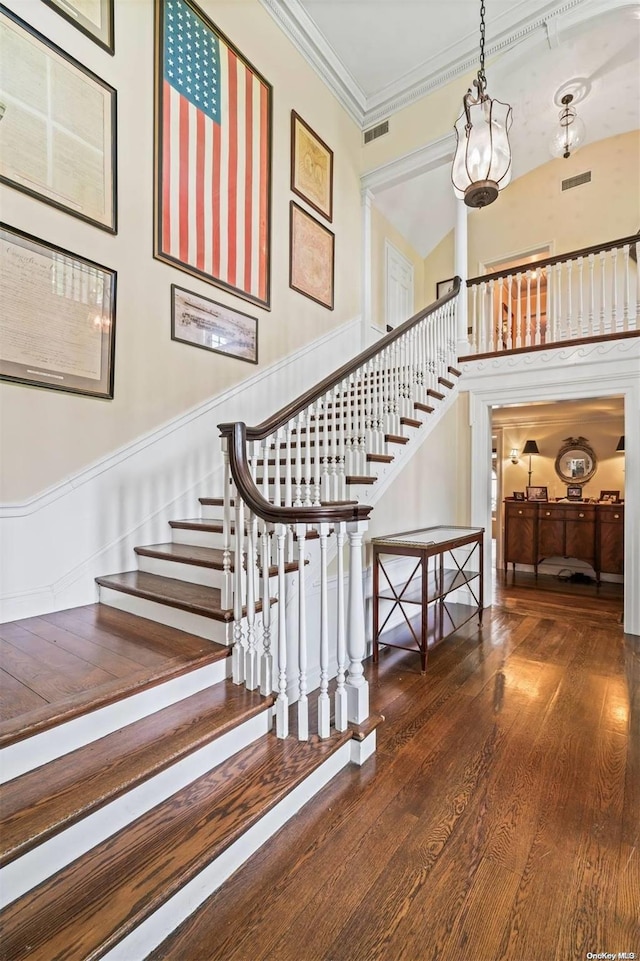 staircase featuring crown molding and hardwood / wood-style flooring