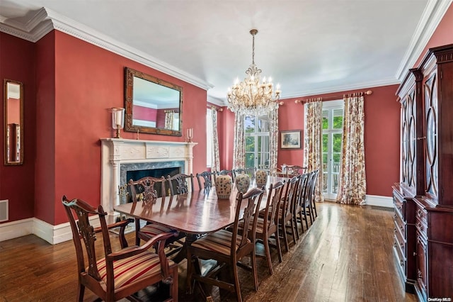 dining room with a premium fireplace, an inviting chandelier, dark hardwood / wood-style floors, and ornamental molding