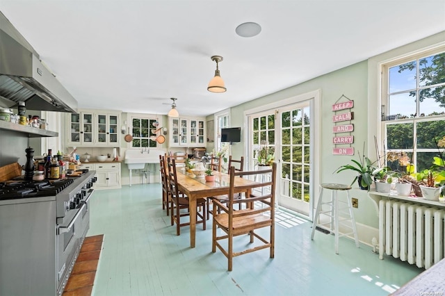 dining area with indoor bar, radiator, and light hardwood / wood-style flooring