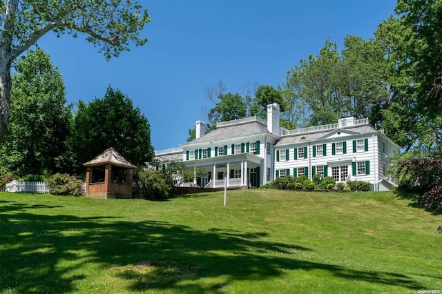 back of house with a gazebo and a yard